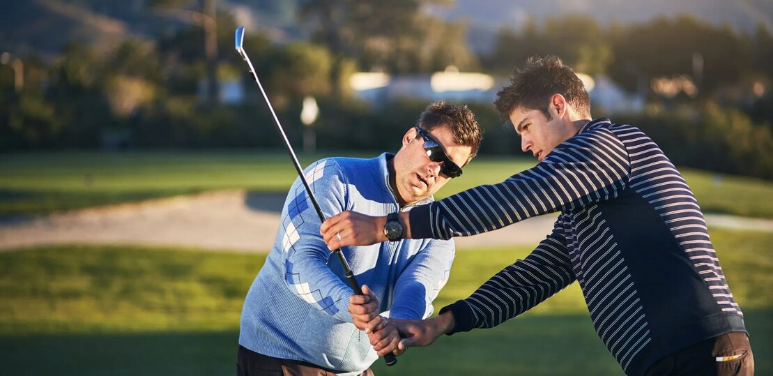 Maestro di golf che segue un gruppo di allievi in campo